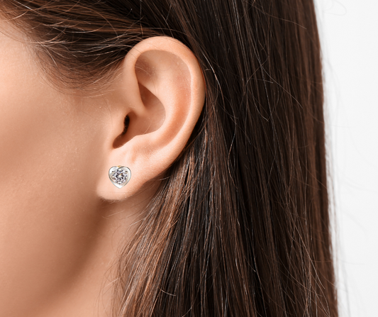 Close-up of an ear wearing a moissanite stud earring with hair partially obscuring the view.