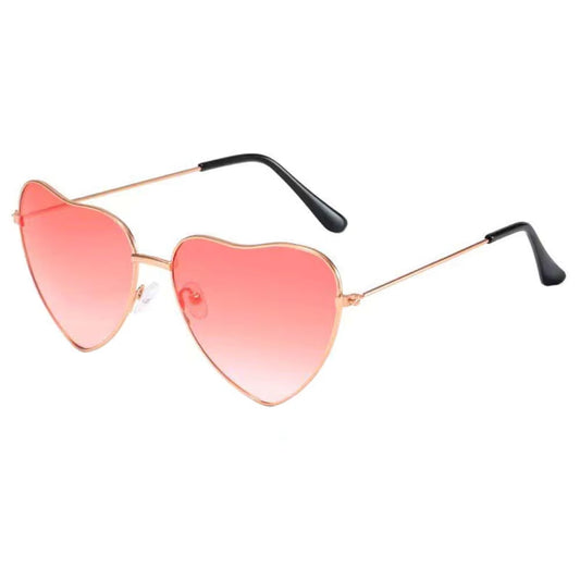 Heart-shaped sunglasses with pink lenses and gold frames on a white background