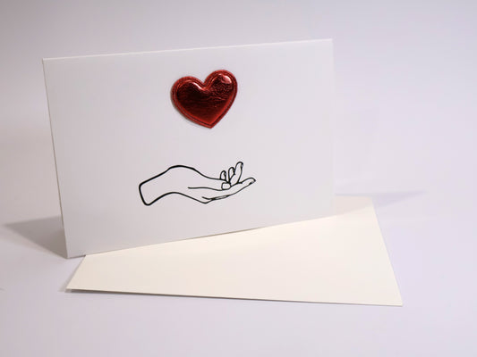 Greeting card with a red heart and a hand holding a ring on a white background