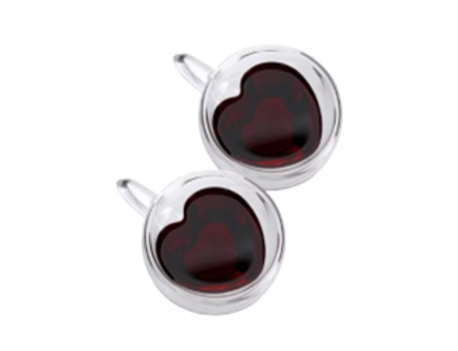 Heart-shaped glass cups with red liquid on a white background
