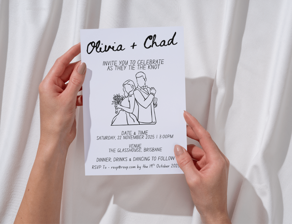 Hand holding a wedding invitation card with a couple illustration on a white background
