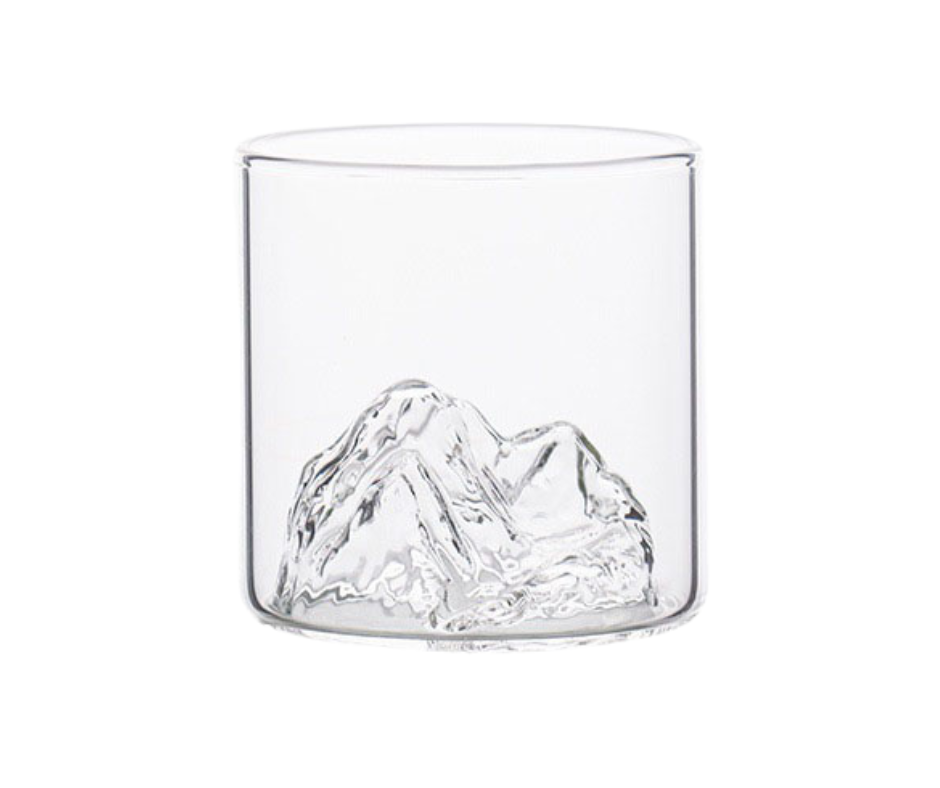 Clear glass tumbler with mountain design on a white background