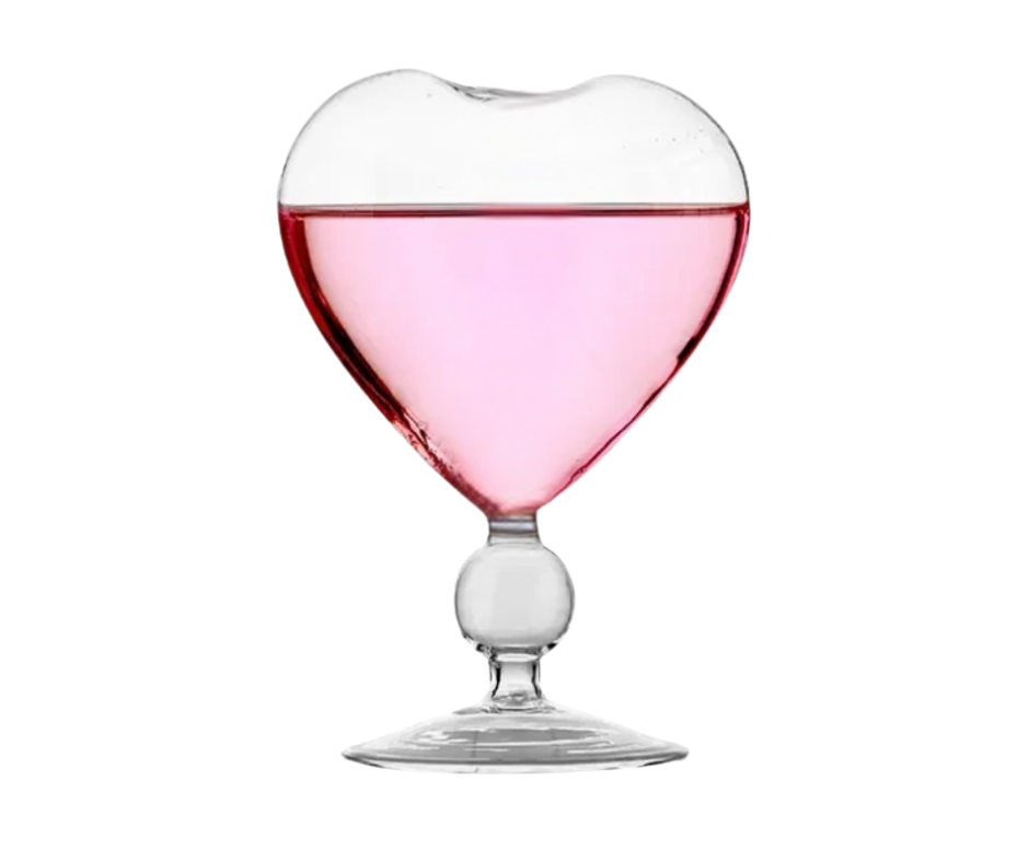 Heart-shaped cocktail glass filled with pink liquid on a white background