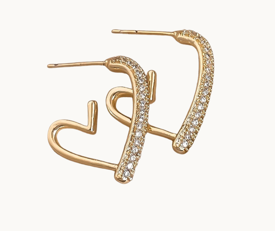 Gold earrings with heart design and clear stones on a white background