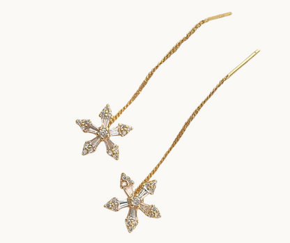 Gold flower-shaped earrings on a white background