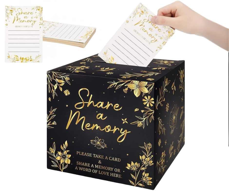 Black box with gold floral designs and 'Share a Memory' text, featuring a hand placing a card into it.