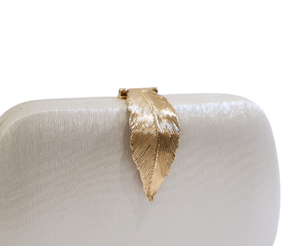 Gold leaf-shaped clasp on a white clutch bag