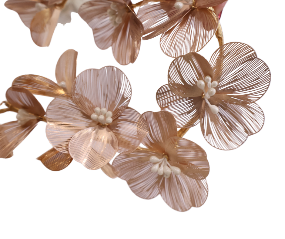 Close-up of decorative floral hair piece in gold on a white background