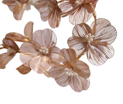 Close-up of decorative floral hair piece in gold on a white background