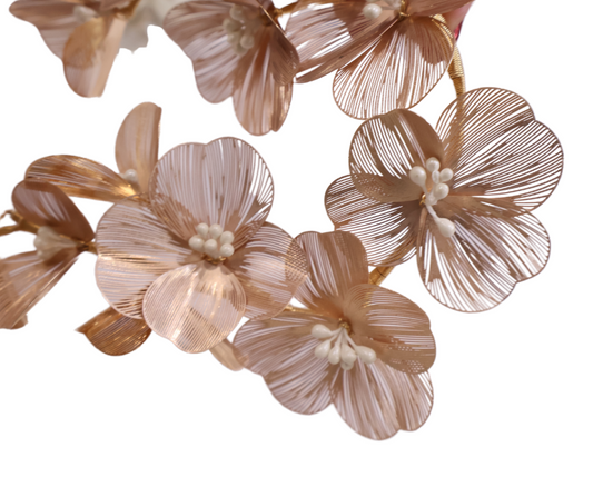 Close-up of decorative floral hair piece in gold on a white background