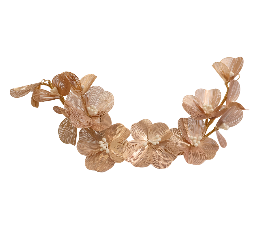 Decorative floral hairpiece with gold leaves on a white background