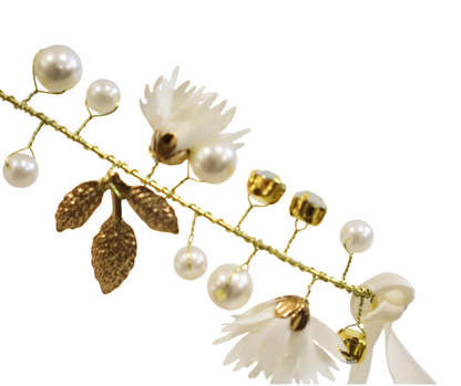 Decorative hairpiece with pearls, flowers, and leaves on a white background