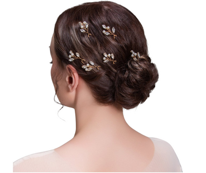 Bride with intricately styled hair using decorative hairpins on a white background