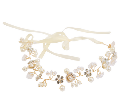 Delicate headband with pearls and flowers on a white background