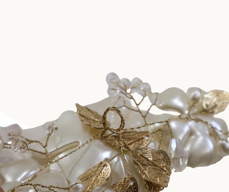 Pearl hairpiece with gold leaves on a white background