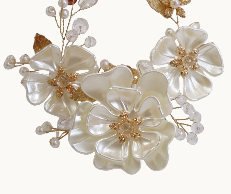 Decorative floral arrangement with white flowers and gold accents on a white background