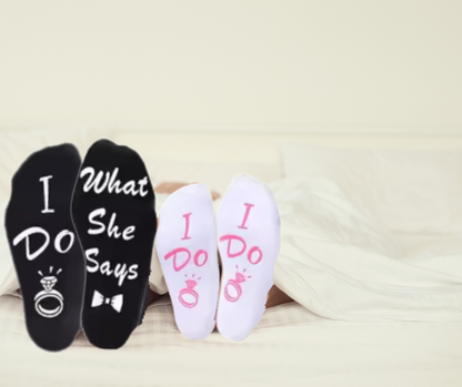 Two pairs of socks with 'I Do' and 'What She Says' text on a light background