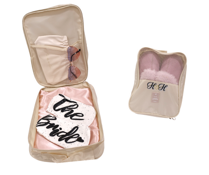 Beige travel case with 'The Bride' socks, robe, sunglasses and wrinkle clutch all packed