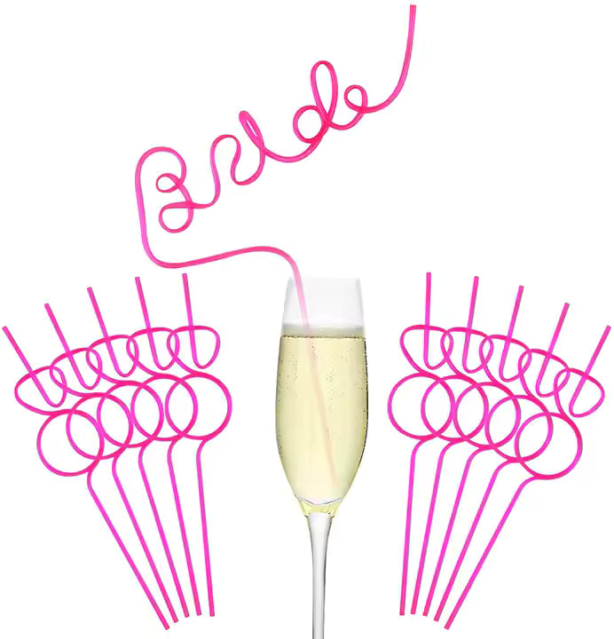 Pink 'Bride' straws with a glass of champagne on a white background