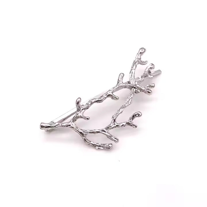 Silver branch-like hair piece on a white background