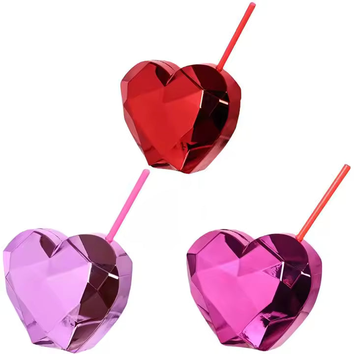Three heart-shaped drink tumblers in red, pink, and purple on a white background