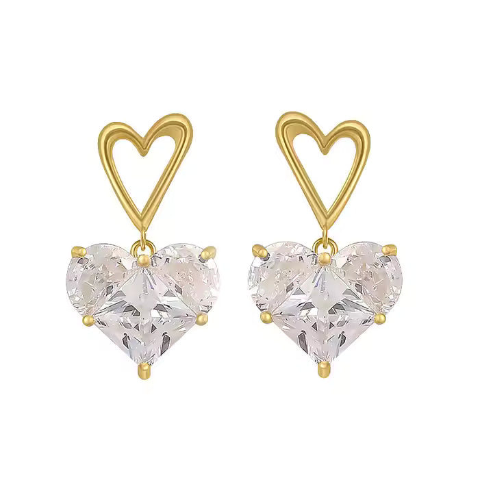 Gold heart-shaped earrings with clear heart-shaped stones on a white background