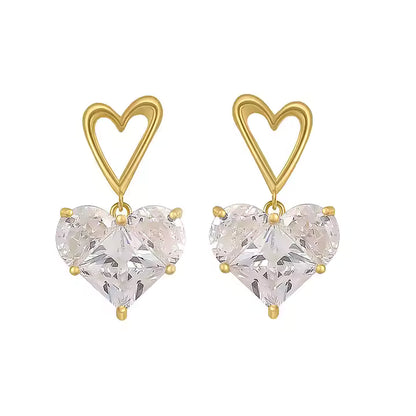Gold heart-shaped earrings with clear heart-shaped stones on a white background
