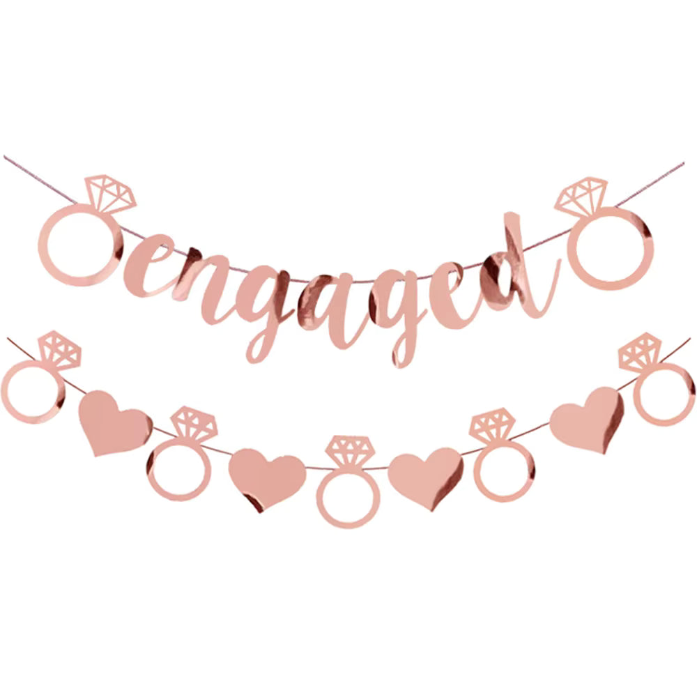 Rose gold 'engaged' banner with rings and hearts on a white background