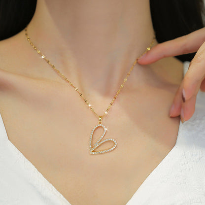 Gold necklace with a heart-shaped pendant on a model