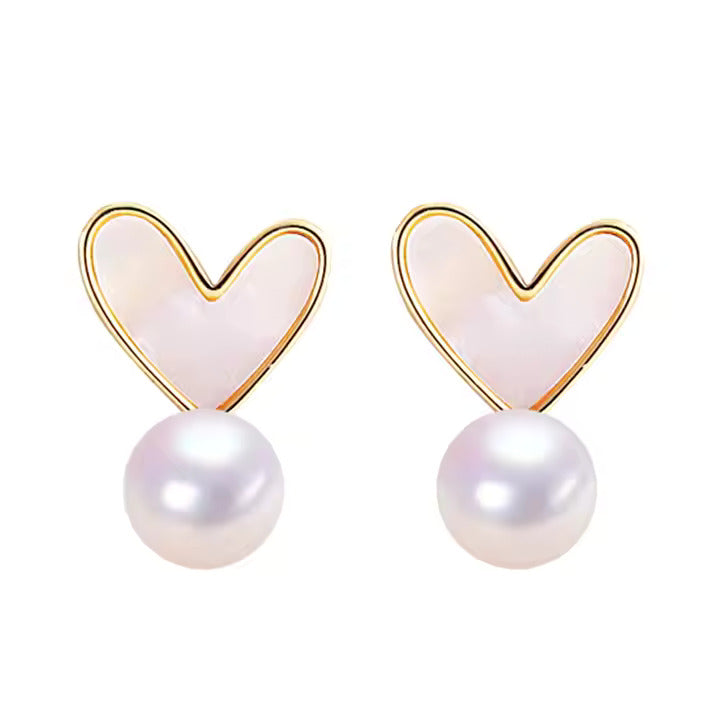 Heart-shaped earrings with pearl drops on a white background