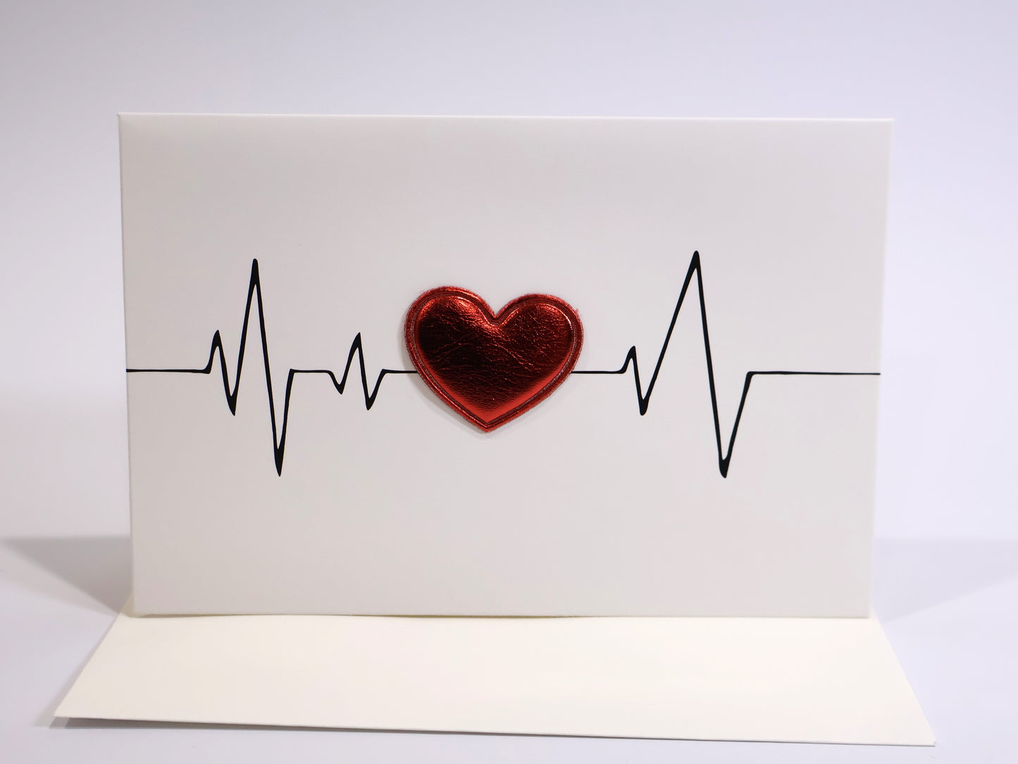 Card with a red heart and heartbeat line on a white background