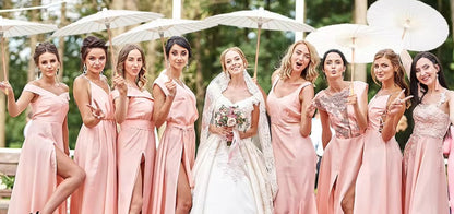 Bride with bridesmaids in pink dresses holding white umbrellas outdoors.