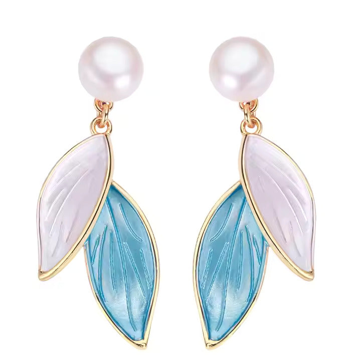 Pair of pearl earrings with leaf-shaped blue and white enamel on a white background