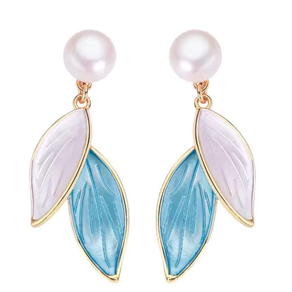 Pair of pearl earrings with leaf-shaped blue and white enamel on a white background