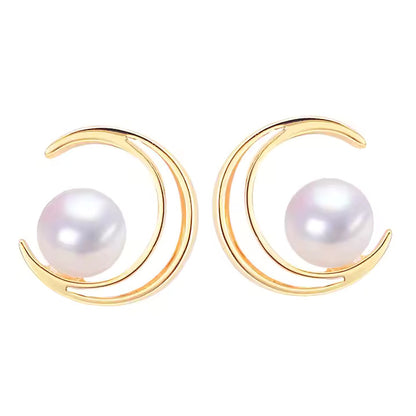 Gold moon shaped earrings with pearl on a white background
