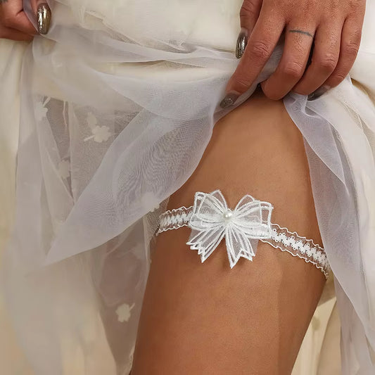 White lace garter with bow detail worn by a bride
