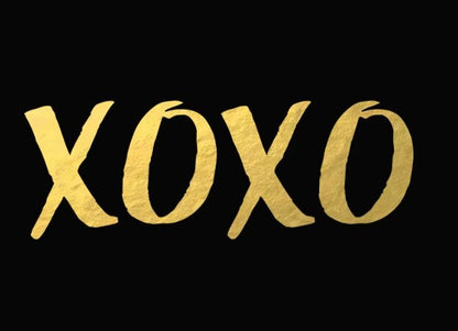 Gold 'XOXO' temporary tattoo on a black background