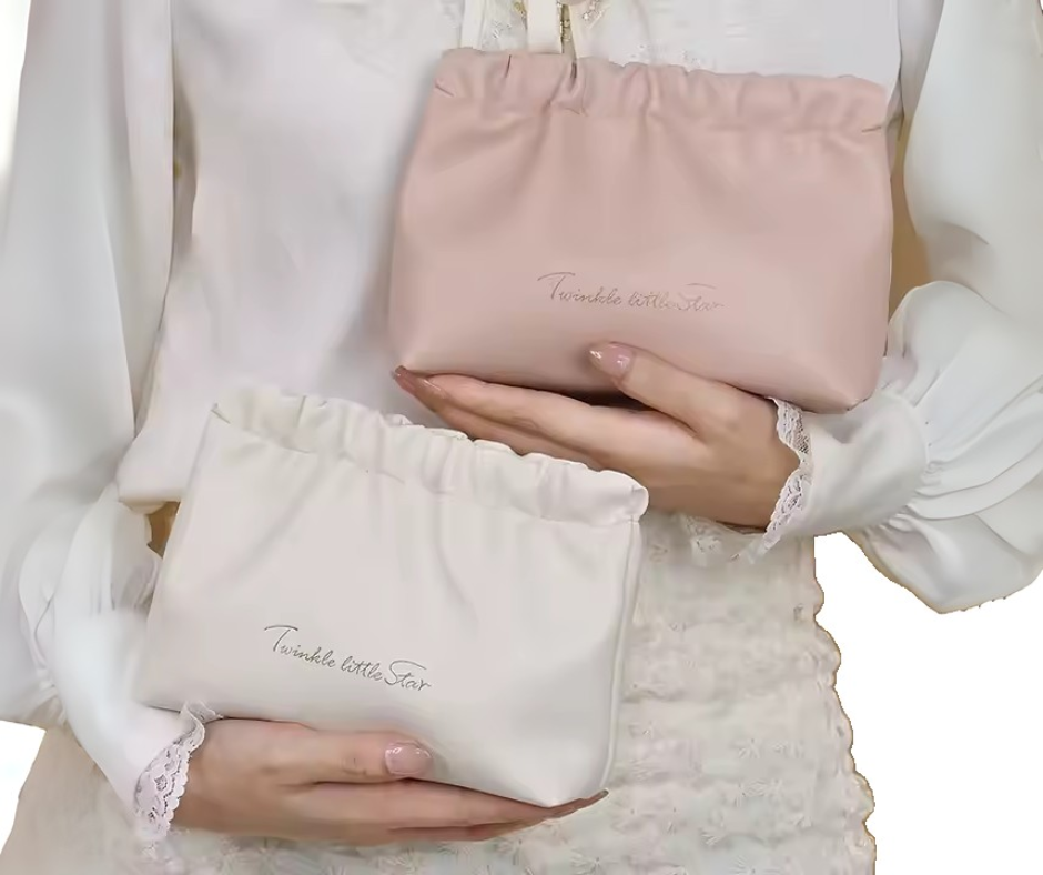 Two pink and white wrinkle clutches held by a person with 'Twinkle little star' text.