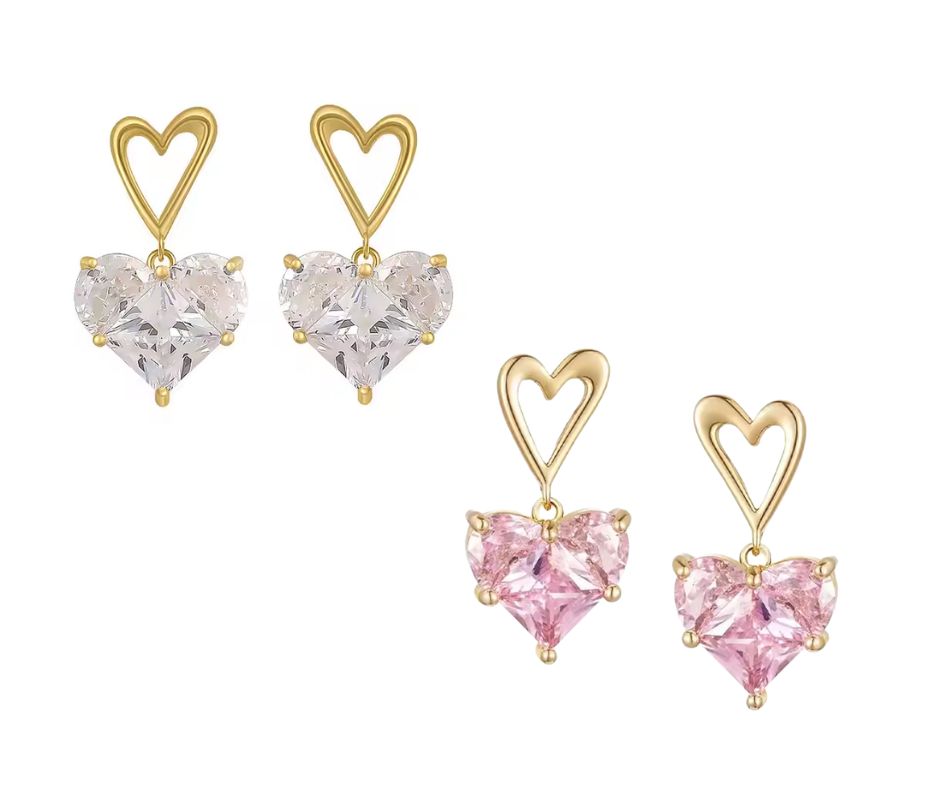 Heart-shaped earrings with gold frames and white and pink gemstones on a white background