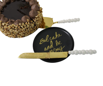 Decorative cake server with a pearl handle and gold blade, featuring the text 'Eat cake and be merry'.