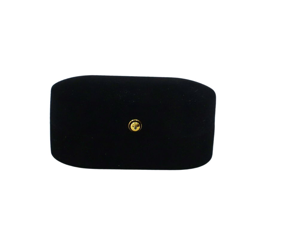 Black rectangular ring box with a gold button on a white background