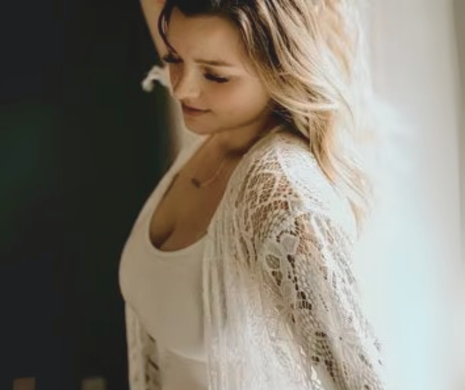 Bride wearing a white lace robe with a blurred background