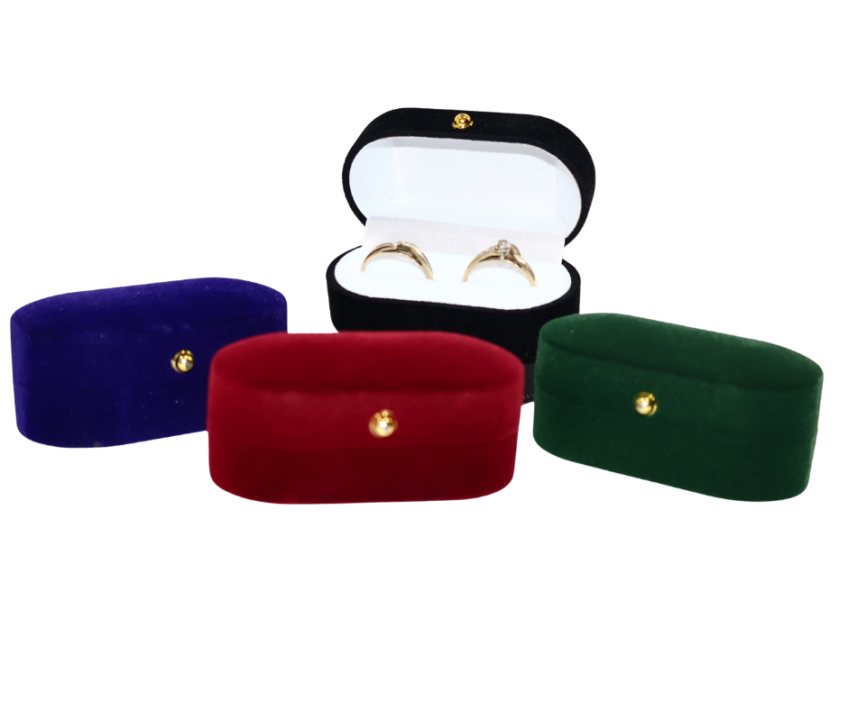 Four velvet double ring boxes in blue,  black red, and green with gold accents on a white background.
