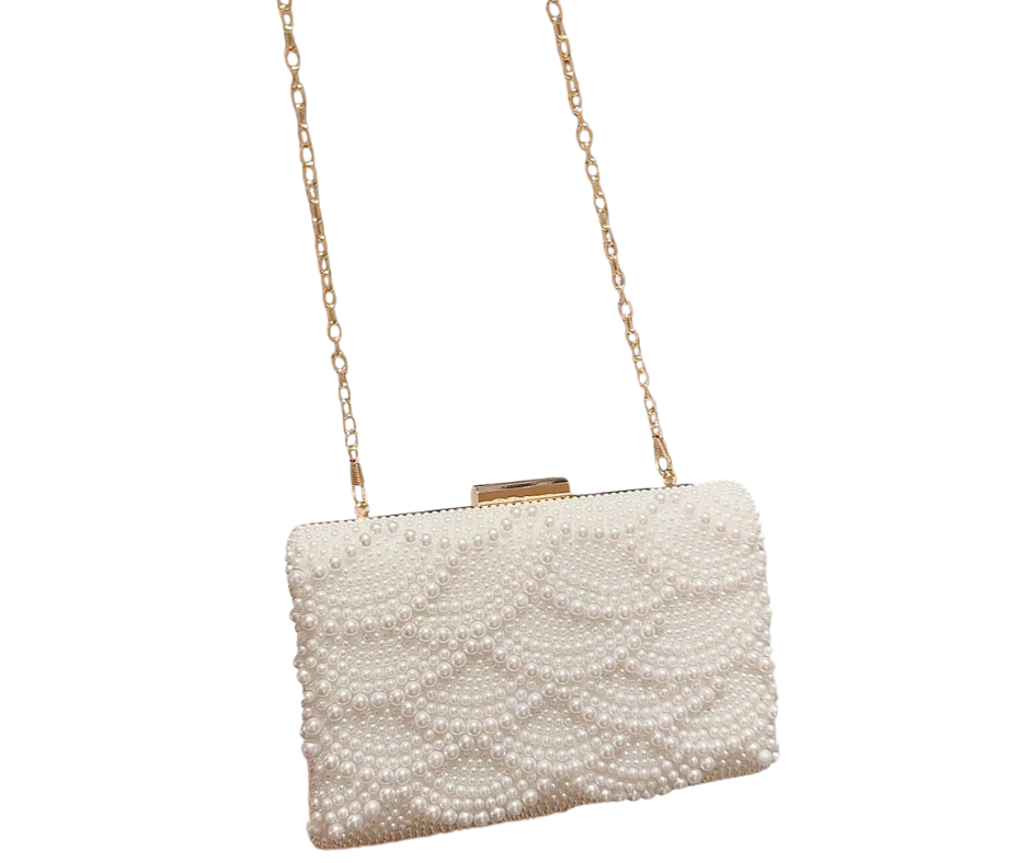 Pearl-handled clutch bag with gold chain strap on a white background