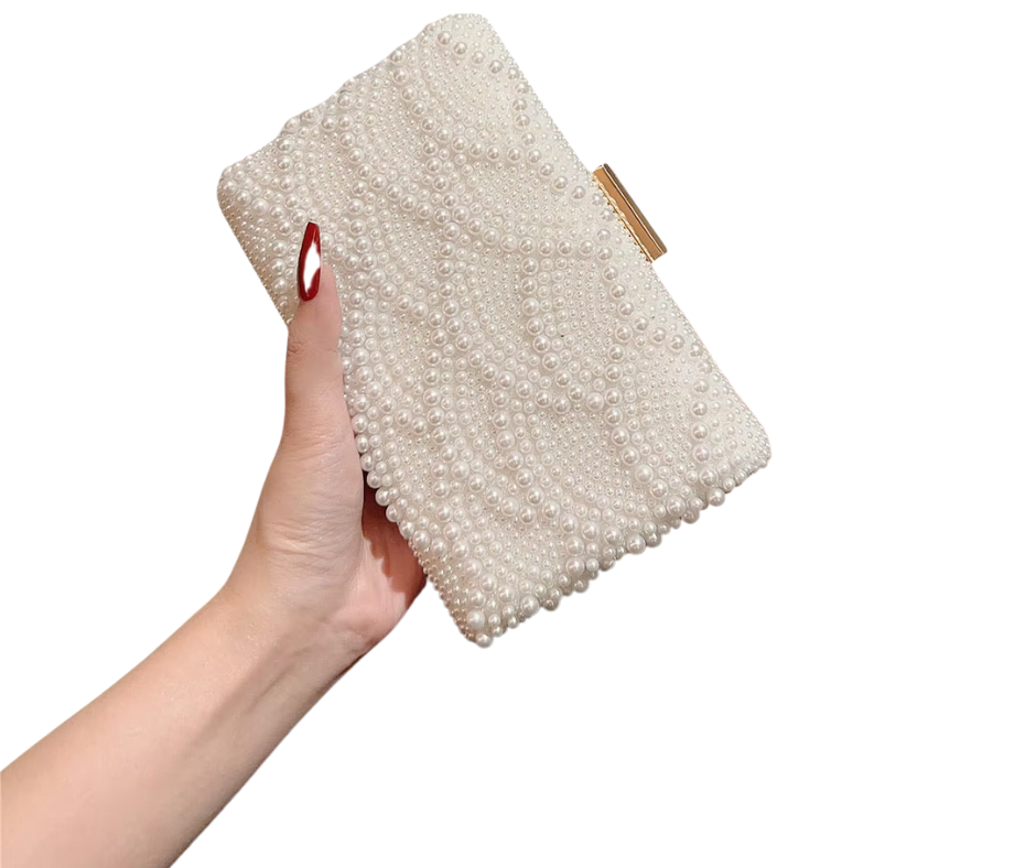 Hand holding a pearl clutch bag against a white background