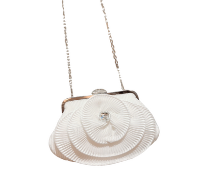White bridal handbag with a chain strap and pleated flower on a white background