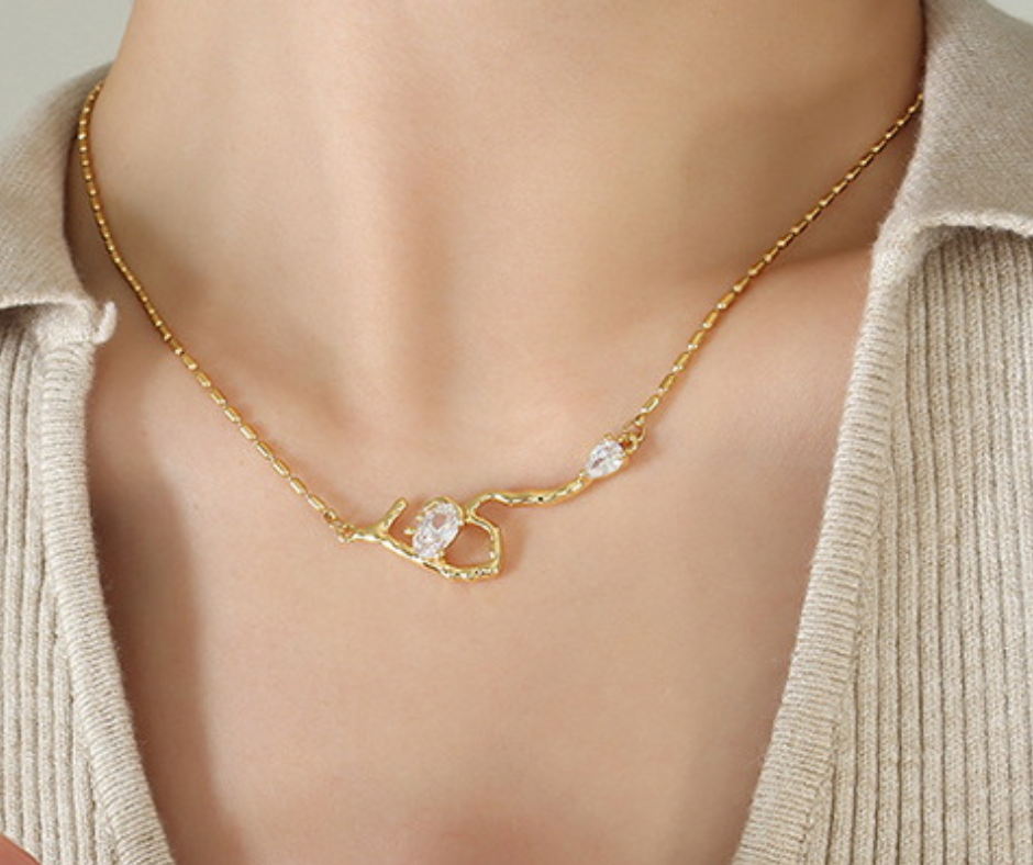 Gold necklace with a branch design worn by a person