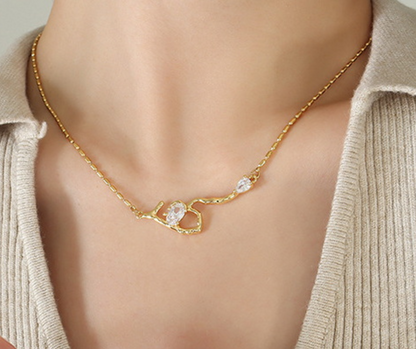 Gold necklace with a branch design worn by a person