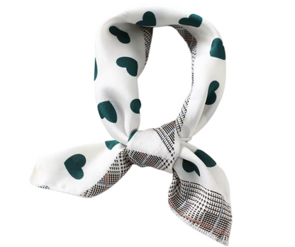White scarf with green heart patterns and checkered border on a white background