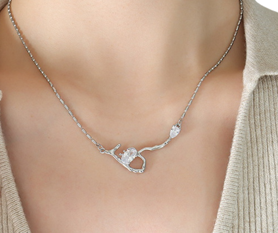 Silver necklace with a branch-shaped pendant on a mannequin